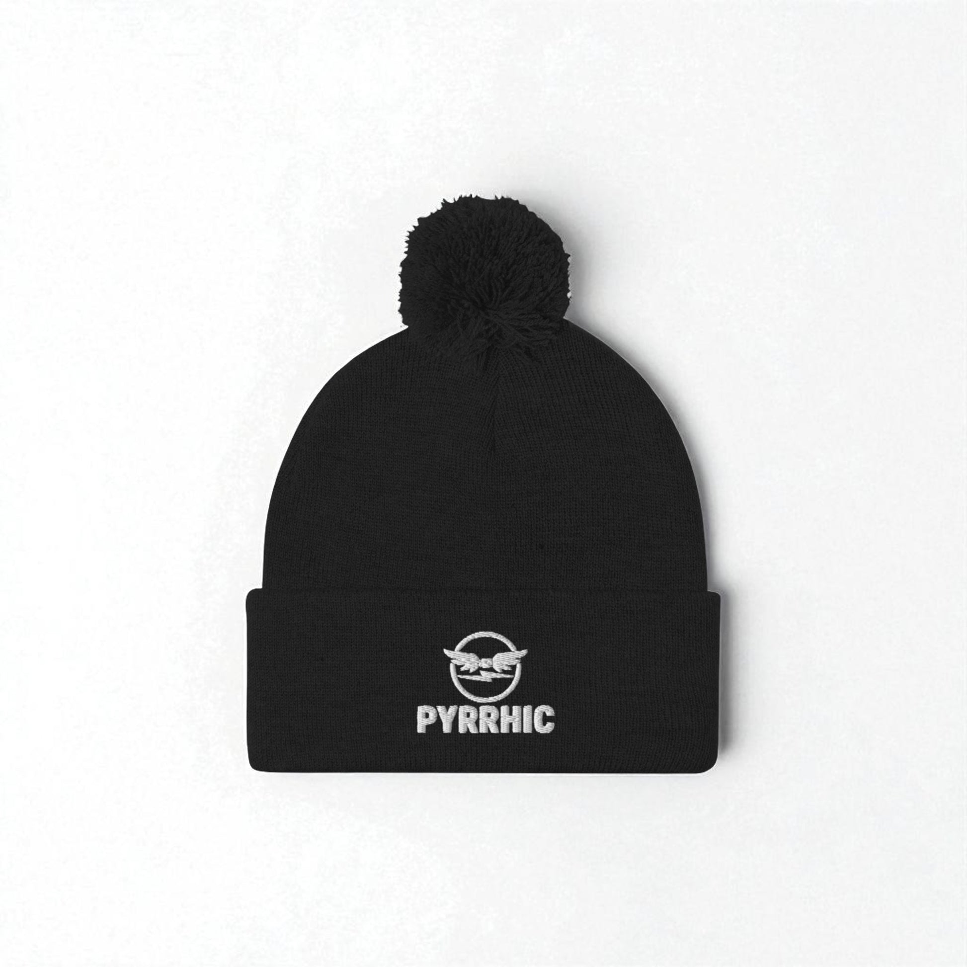 Black beanie with pom-pom and 'PYRRHIC' logo on a white background